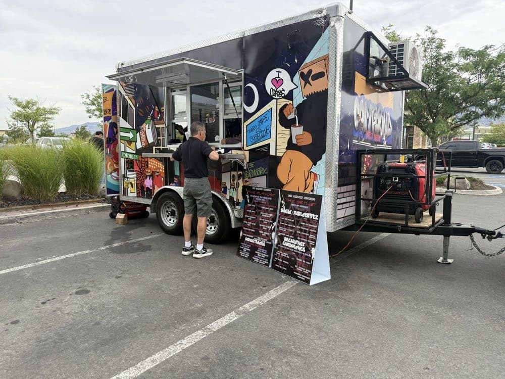 Customer ordering at The Compound truck in a parking lot