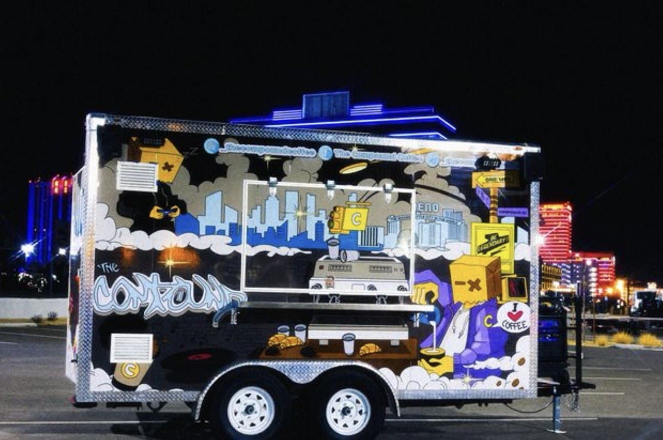 The Compound Coffee truck wrapped in street art, parked at night in front of downtown Reno casinos